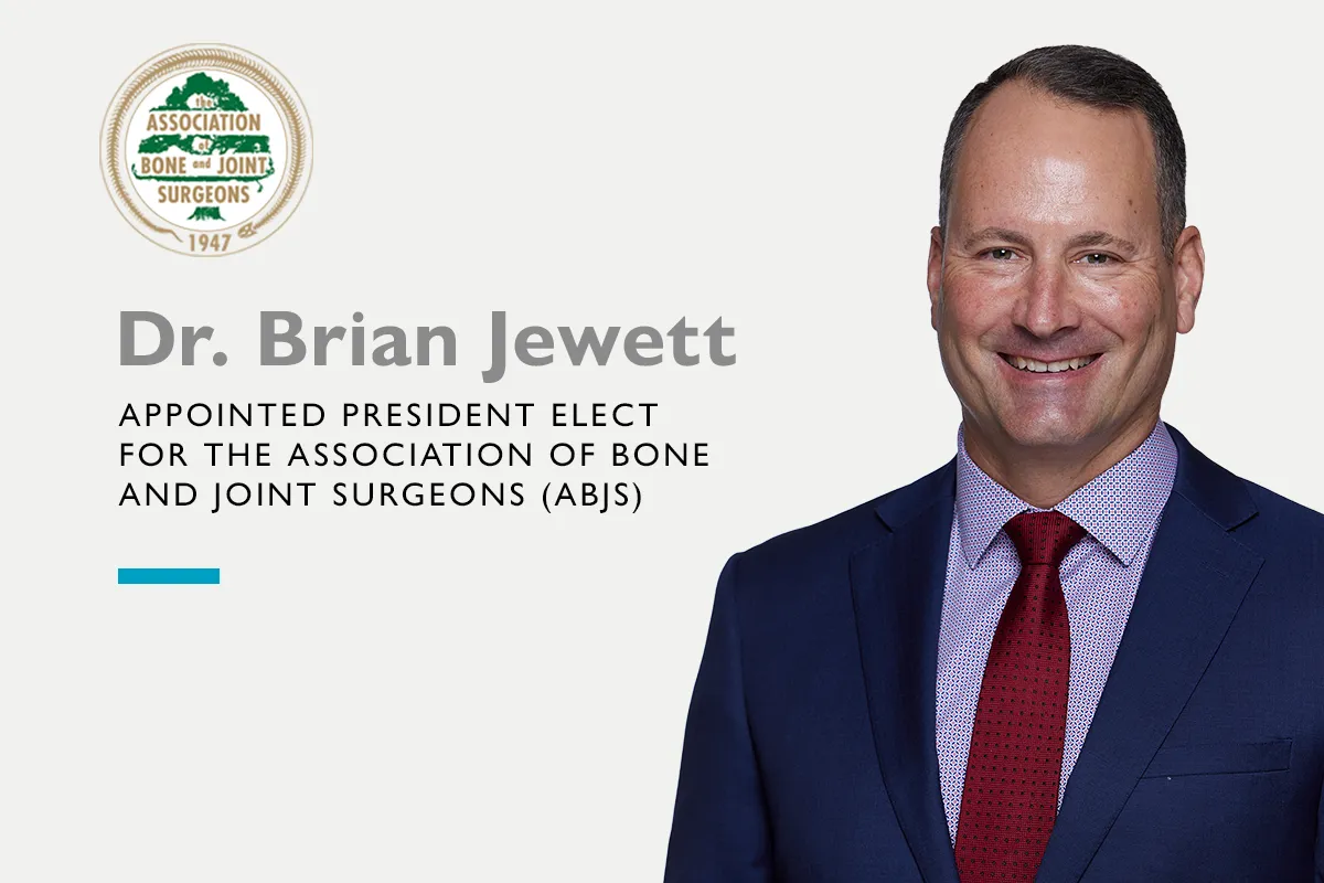 Dr Brian Jewett smiling wearing a suit and tie